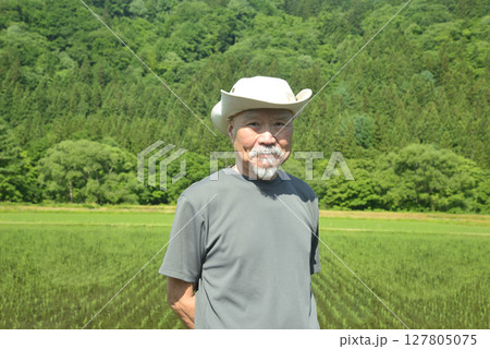 水田を見回る農夫 127805075