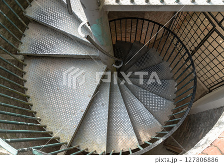 Top view of the distinctive metal steps and railing of steel spiral staircase or spiral staircase ladder. Top view of the distinctive metal steps and railing of steel spiral staircase or spiral staircase ladder. 127806886