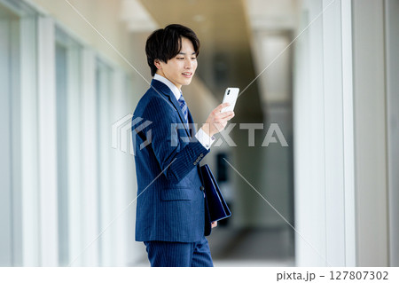 オフィスでスマホを操作するビジネスマン 127807302