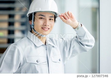 作業服を着た若い男性 127807346