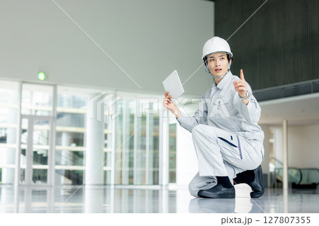 オフィスの廊下に立つ作業服の若い作業員 127807355