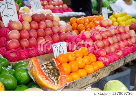 Apples, oranges, papaya, and avocados displayed at tropical fruit market stall with price tags in Philippines Apples, oranges, papaya, and avocados displayed at tropical fruit market stall with price tags in Philippines 127809756