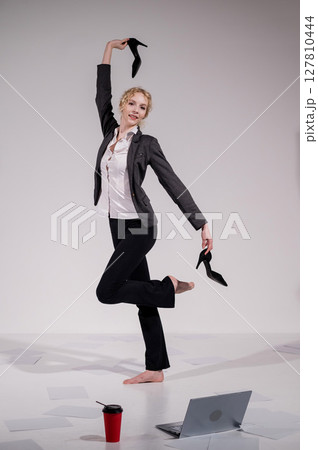 Barefoot ballerina dancing in business suit on white background. Barefoot ballerina dancing in business suit on white background. 127810444