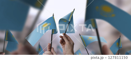Kazakhstan flags in their hands on a blurred urban background Kazakhstan flags in their hands on a blurred urban background 127811150
