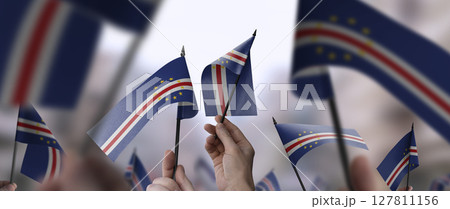 Cape Verde flags in their hands on a blurred urban background 127811156