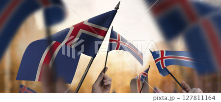 Iceland flags in their hands on a blurred urban background 127811164