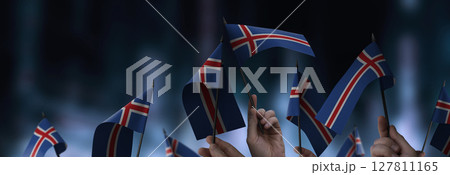 Iceland flags in their hands on a blurred urban background 127811165