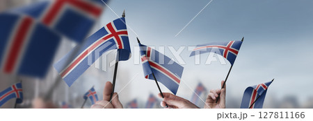 Iceland flags in their hands on a blurred urban background 127811166