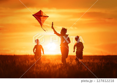 Children with a kite at sunset Children with a kite at sunset 127812218