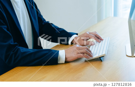 パソコンで作業をする男性の手元 127812816