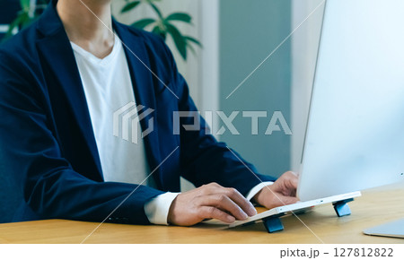 パソコンで作業をする男性の手元 127812822
