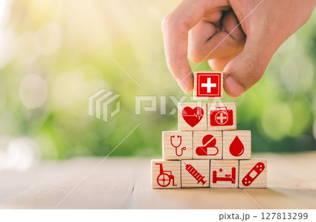 Hand arranged wooden blocks with icons of medical health. health insurance for your health concept. Healthcare medical business. Hand arranged wooden blocks with icons of medical health. health insurance for your health concept. Healthcare medical business. 127813299