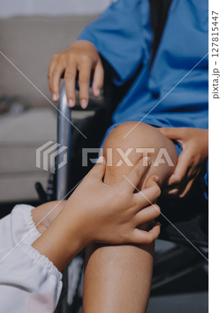 Physiotherapist checking knee of female patient stock Physiotherapist checking knee of female patient stock 127815447