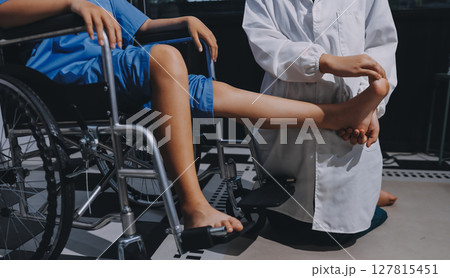 Physiotherapist checking knee of female patient stock Physiotherapist checking knee of female patient stock 127815451