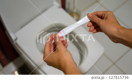 A woman takes an express pregnancy test. A woman takes an express pregnancy test. 127815736