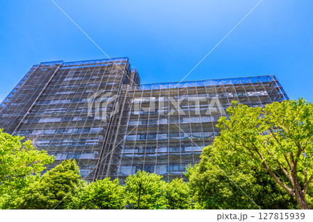 日本の横浜都市景観　マンションの補修や点検等、足場や防護ネットなど。ネットの外に衛星アンテナが… 127815939