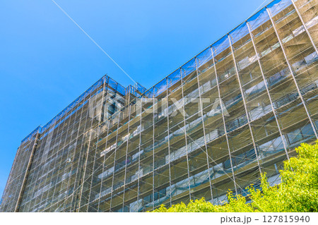 日本の横浜都市景観　マンションの補修や点検等、足場や防護ネットなど。ネットの外に衛星アンテナが… 127815940