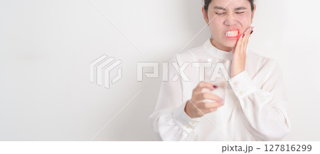 Business woman having toothache and pain after drink ice water for concept of Teeth Sensitive to Cold, Tooth Decay and Gum Disease, Grinding Teeth and Stress, Exposed Nerve Roots, Crack and Receding Business woman having toothache and pain after drink ice water for concept of Teeth Sensitive to Cold, Tooth Decay and Gum Disease, Grinding Teeth and Stress, Exposed Nerve Roots, Crack and Receding 127816299