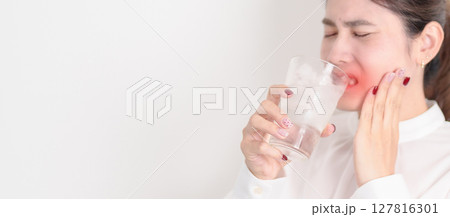 Business woman having toothache and pain after drink ice water for concept of Teeth Sensitive to Cold, Tooth Decay and Gum Disease, Grinding Teeth and Stress, Exposed Nerve Roots, Crack and Receding 127816301