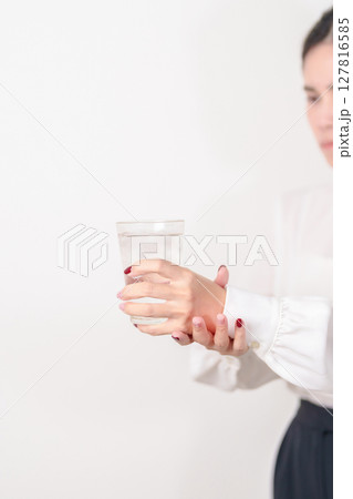 Business woman having Tremor hand during hold water glass. Parkinson disease April awareness month, Carpal Tunnel Syndrome, rheumatoid and brain injury, Neurological disorder and health care concept Business woman having Tremor hand during hold water glass. Parkinson disease April awareness month, Carpal Tunnel Syndrome, rheumatoid and brain injury, Neurological disorder and health care concept 127816585