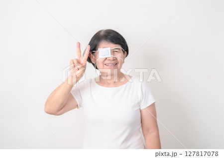 Elderly Woman with Eye protecting by Eye Pad for concepts of Eye disease, Cataract, Glaucoma, Age Related Macular Degeneration, Diabetic Retinopathy, Vitreous, Conjunctivitis, World Glaucoma day 127817078