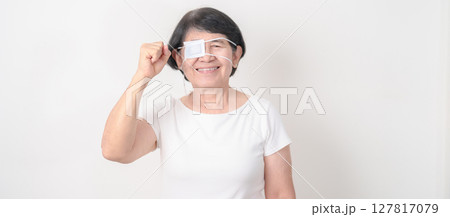 Elderly Woman with Eye protecting by Eye Pad for concepts of Eye disease, Cataract, Glaucoma, Age Related Macular Degeneration, Diabetic Retinopathy, Vitreous, Conjunctivitis, World Glaucoma day Elderly Woman with Eye protecting by Eye Pad for concepts of Eye disease, Cataract, Glaucoma, Age Related Macular Degeneration, Diabetic Retinopathy, Vitreous, Conjunctivitis, World Glaucoma day 127817079