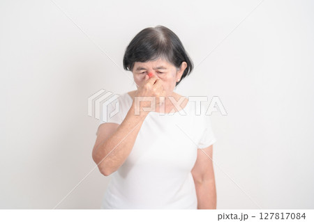 Elderly  Woman having Nose pain for concepts of Nose disease, Common Cold, Influenza, Flu, Covid 19, Respiratory Infection, Sinusitis, Allergic Rhinitis, Asthma, Allergy, Dry nose Anosmia and Health 127817084