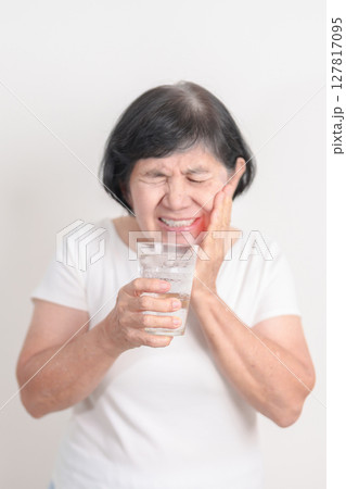 Elderly woman having toothache and pain after drink ice water for concept of Teeth Sensitive to Cold, Tooth Decay and Gum Disease, Grinding Teeth and Stress, Exposed Nerve Roots, Crack and Receding 127817095