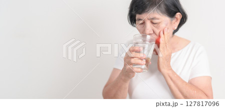 Elderly woman having toothache and pain after drink ice water for concept of Teeth Sensitive to Cold, Tooth Decay and Gum Disease, Grinding Teeth and Stress, Exposed Nerve Roots, Crack and Receding Elderly woman having toothache and pain after drink ice water for concept of Teeth Sensitive to Cold, Tooth Decay and Gum Disease, Grinding Teeth and Stress, Exposed Nerve Roots, Crack and Receding 127817096