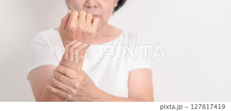 Elderly Woman having wrist pain with Medicated pain relief patch plaster for Carpal Tunnel Syndrome, Wrist Tendinitis, muscle ache, De Quervain s tenosynovitis, Hand Osteoarthritis and Senior health Elderly Woman having wrist pain with Medicated pain relief patch plaster for Carpal Tunnel Syndrome, Wrist Tendinitis, muscle ache, De Quervain s tenosynovitis, Hand Osteoarthritis and Senior health 127817419