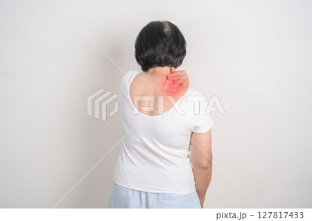 Elderly Woman having Shoulder Pain with Medicated pain relief patch plaster for Muscle Inflammation and Sprain, Myofascial ache syndrome and Fibromyalgia, Shoulder Myalgia and Scapular Tightness 127817433