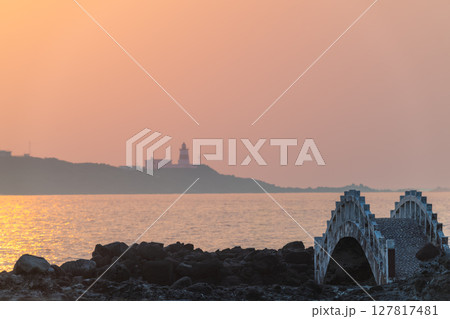 Sunset Glow Over Shimen Coastline and Fuguijiao Lighthouse New Taipei City. 127817481
