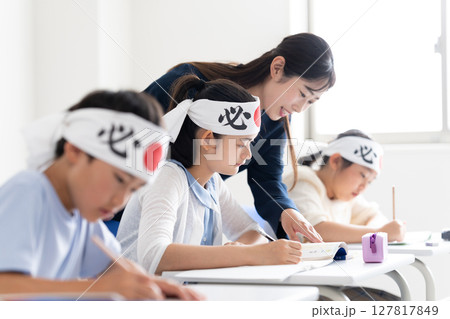 必勝の鉢巻をして塾で勉強する子供達 必勝の鉢巻をして塾で勉強する子供達 127817849