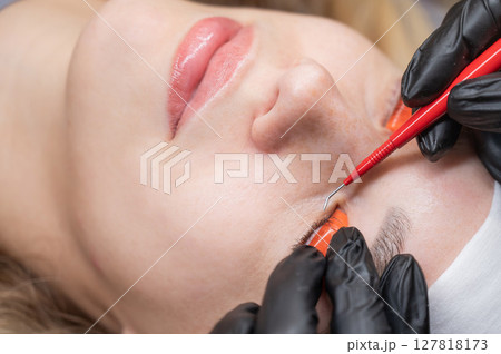 Caucasian woman undergoing eyelash lamination procedure.  127818173