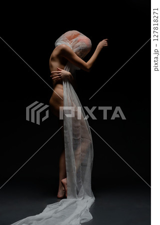 Red woman poses gracefully with sheer fabric in artistic display of beauty Red woman poses gracefully with sheer fabric in artistic display of beauty 127818271