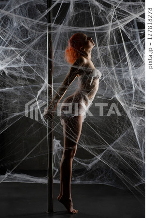 Red woman captured in a web of netting during an artistic performance Red woman captured in a web of netting during an artistic performance 127818278