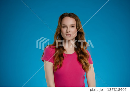 Woman posing in a studio setting with a bright blue background, conveying a range of emotions and expressions Woman posing in a studio setting with a bright blue background, conveying a range of emotions and expressions 127818405