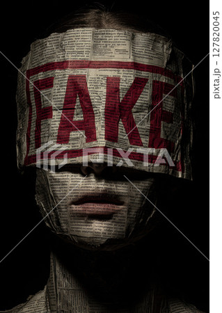 Anonymous person with word Fake across face 127820045
