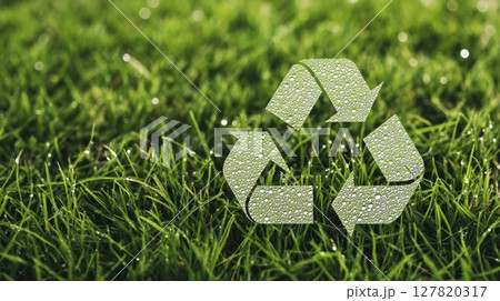 Recycling symbol made of water drops on vibrant green grass promoting environmental sustainability and eco conscious practices for a greener future 127820317