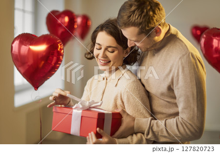 Valentine day gift box giving, love feeling, romantic surprise, happy loving couple in tender hug Valentine day gift box giving, love feeling, romantic surprise, happy loving couple in tender hug 127820723