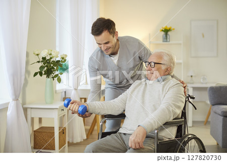 Elderly Patient In Wheelchair Doing Exercise With Dumbbell And Physiotherapist 127820730