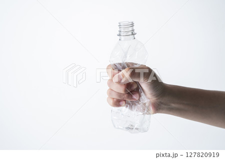 空のペットボトルを潰す男性の手 127820919