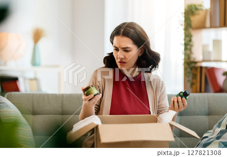 Woman is unpacking cardboard 127821308