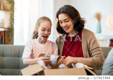 Mother and daughter are unpacking cardboard 127821468