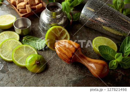 Wooden citrus squeezer, shaker, and ingredients for making summer refreshing drinks. 127821498