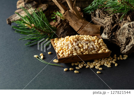 Peeled pine nuts with cedar dried snags and green branches. 127821544
