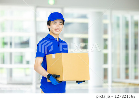 荷物を運ぶ男性配達員 127821568