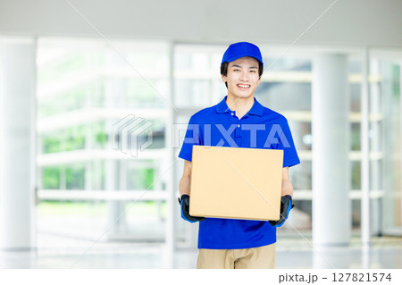 荷物を運ぶ男性配達員 荷物を運ぶ男性配達員 127821574