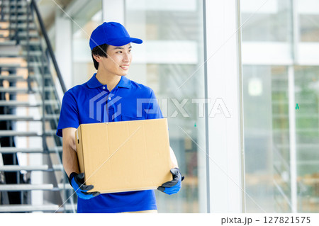 荷物を運ぶ男性配達員 荷物を運ぶ男性配達員 127821575