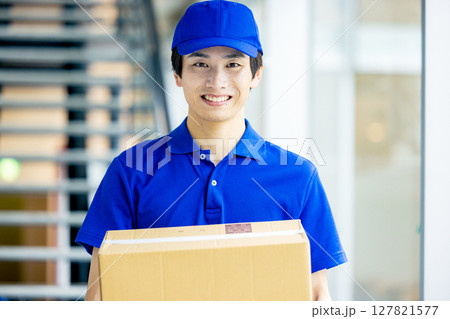 荷物を運ぶ男性配達員 127821577
